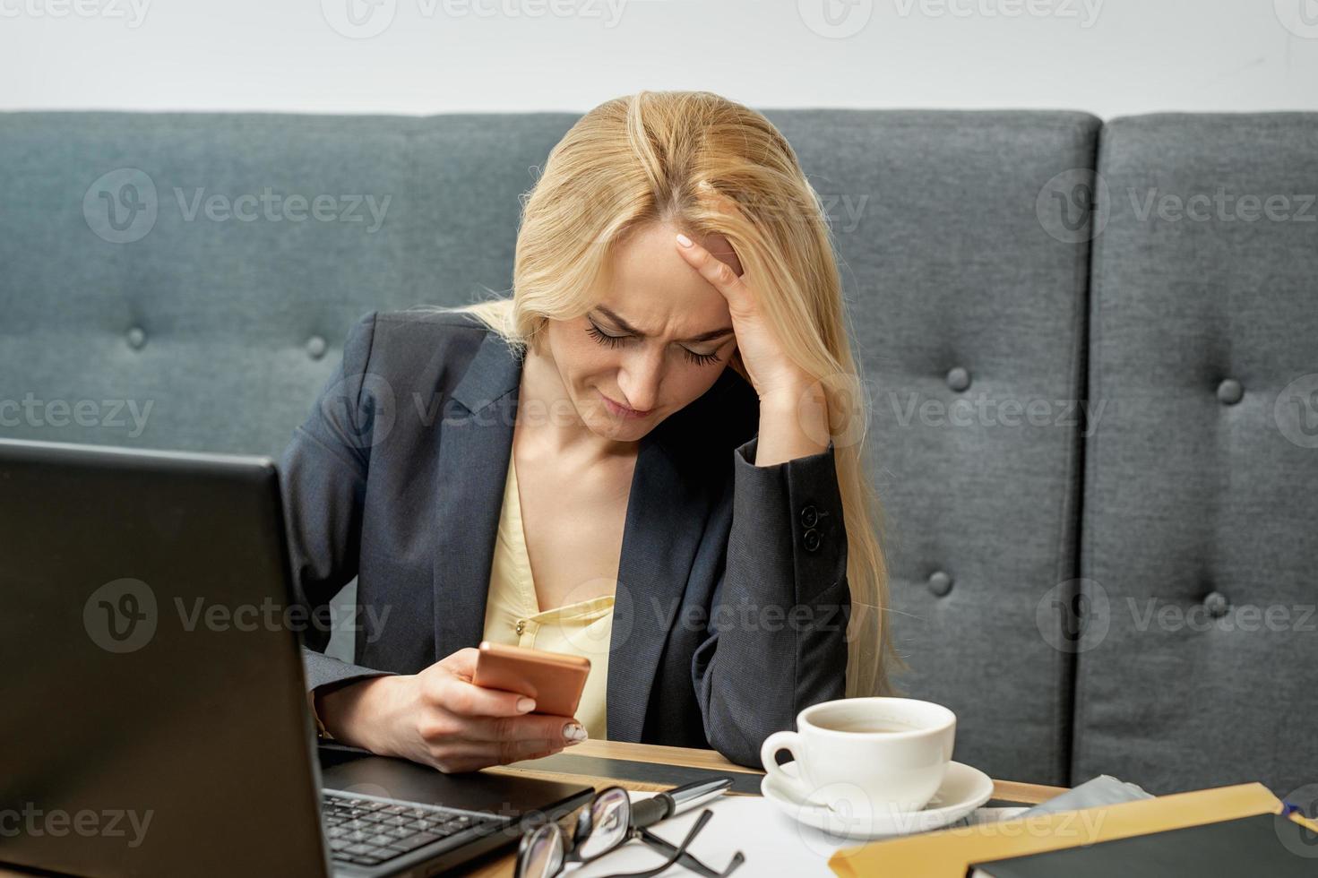 Woman looking upset while using smartphone. photo