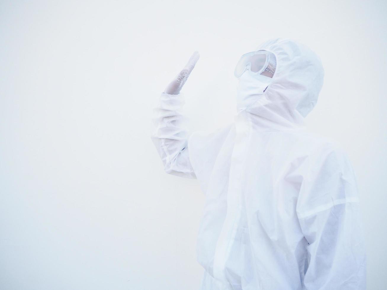 Asian male doctor or scientist in PPE suite uniform showing stop sign while looking ahead. coronavirus or COVID-19 concept isolated white background photo