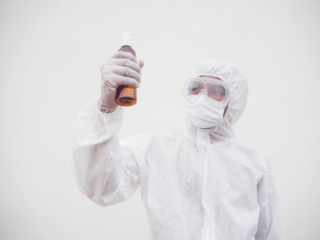 retrato de médico o científico con uniforme de suite de ppe sosteniendo una botella de plástico con un producto para el cuidado de la piel. covid-19 concepto aislado fondo blanco foto