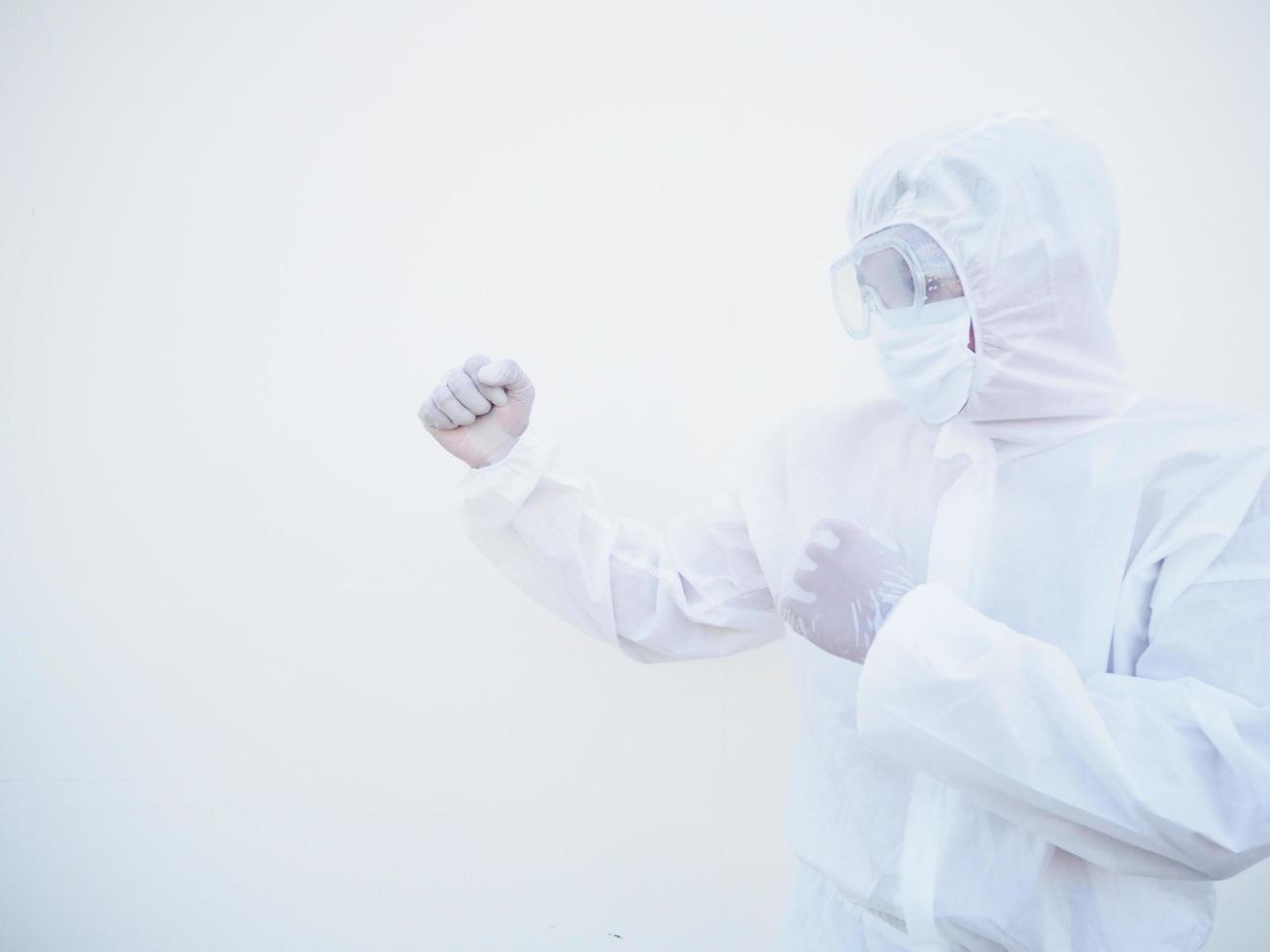 vista lateral médico o científico en uniforme de suite ppe de pie con puños levantados como boxeador para pelear con coronavirus o covid-19 fondo blanco aislado foto