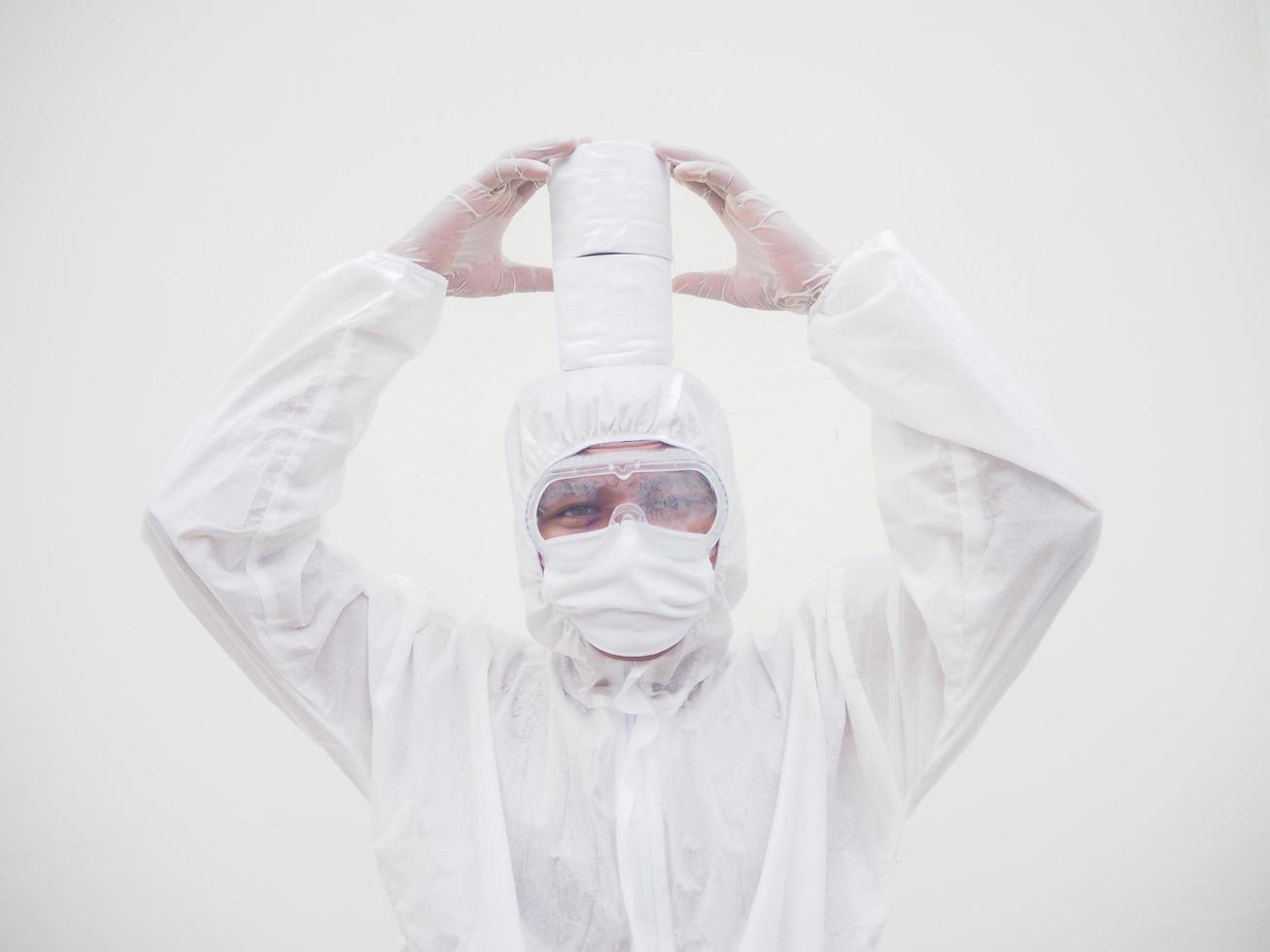 Asian male doctor or scientist in PPE suite uniform holding toilet paper. Lack of toilet paper in the quarantine of coronavirus. COVID-19 concept isolated white background photo