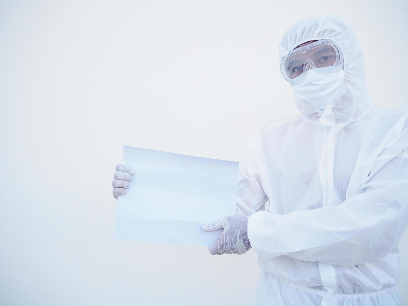 joven médico o científico con uniforme de suite ppe sosteniendo papel en blanco para texto con ambas manos mientras mira hacia adelante. concepto de coronavirus o covid-19 fondo blanco aislado foto