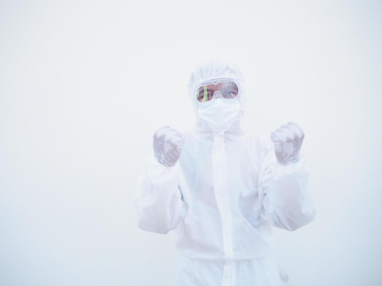 médico o científico asiático emocional exitoso en uniforme de suite ppe mientras mira hacia adelante. aprieta los puños con placer, felicidad, celebra su victoria, tiene un gran triunfo. fondo blanco aislado foto