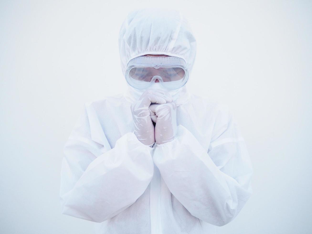 Closeup of asian male doctor or scientist in PPE suite uniform has stress and pray during an outbreak of coronavirus or COVID-19 isolated white background. photo