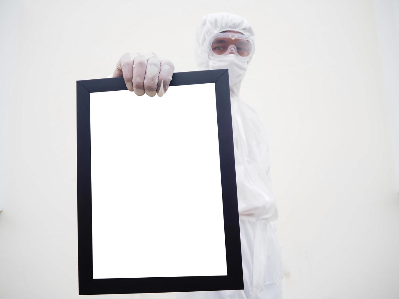 médico o científico asiático con uniforme de suite ppe. sosteniendo marcos negros cuadrados de pantalla blanca para su diseño. concepto de coronavirus o covid-19 fondo blanco aislado foto