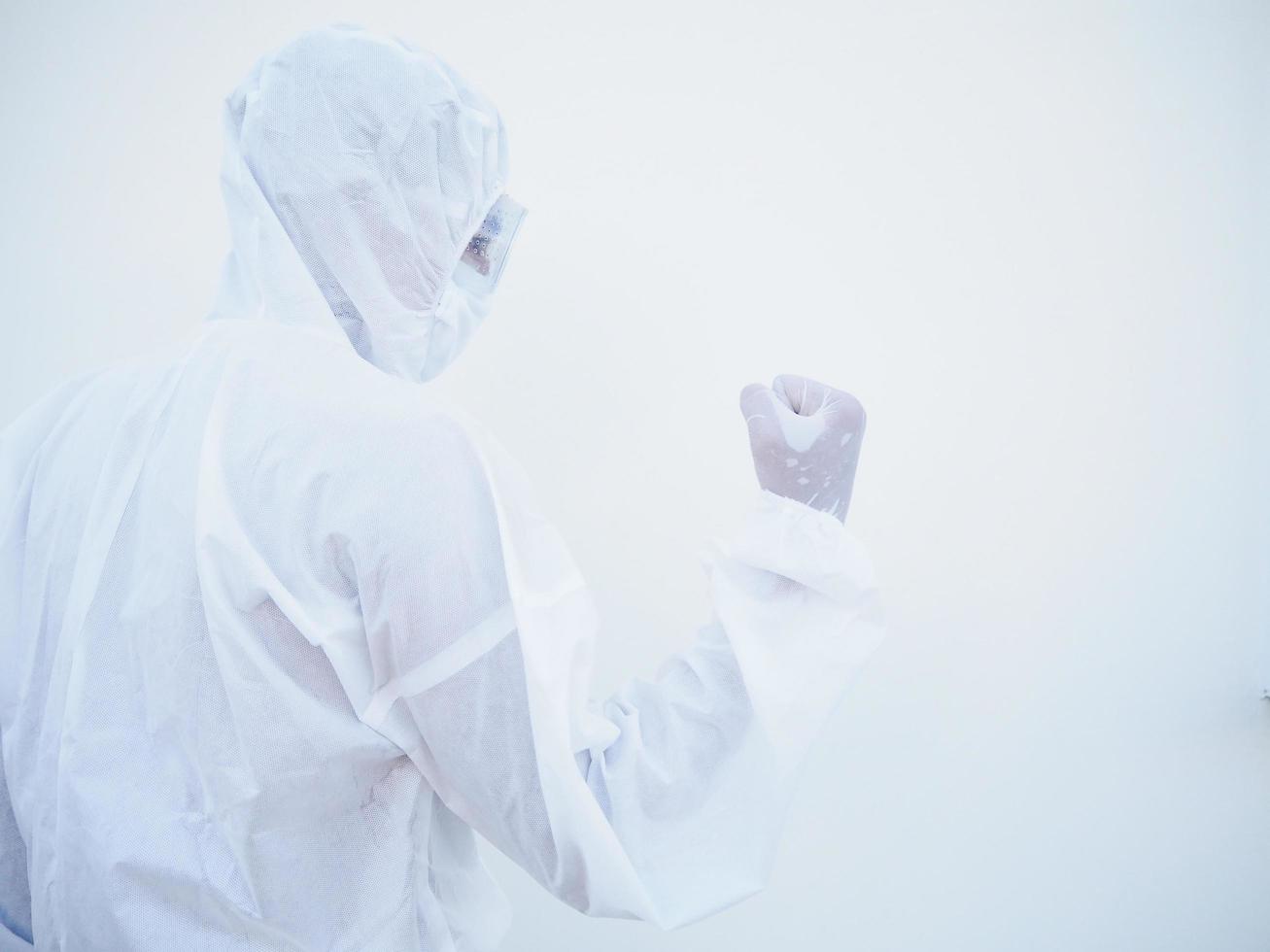 médico o científico asiático emocional exitoso en uniforme de suite ppe mientras mira hacia adelante. aprieta los puños con placer, felicidad, celebra su victoria, tiene un gran triunfo. fondo blanco aislado foto