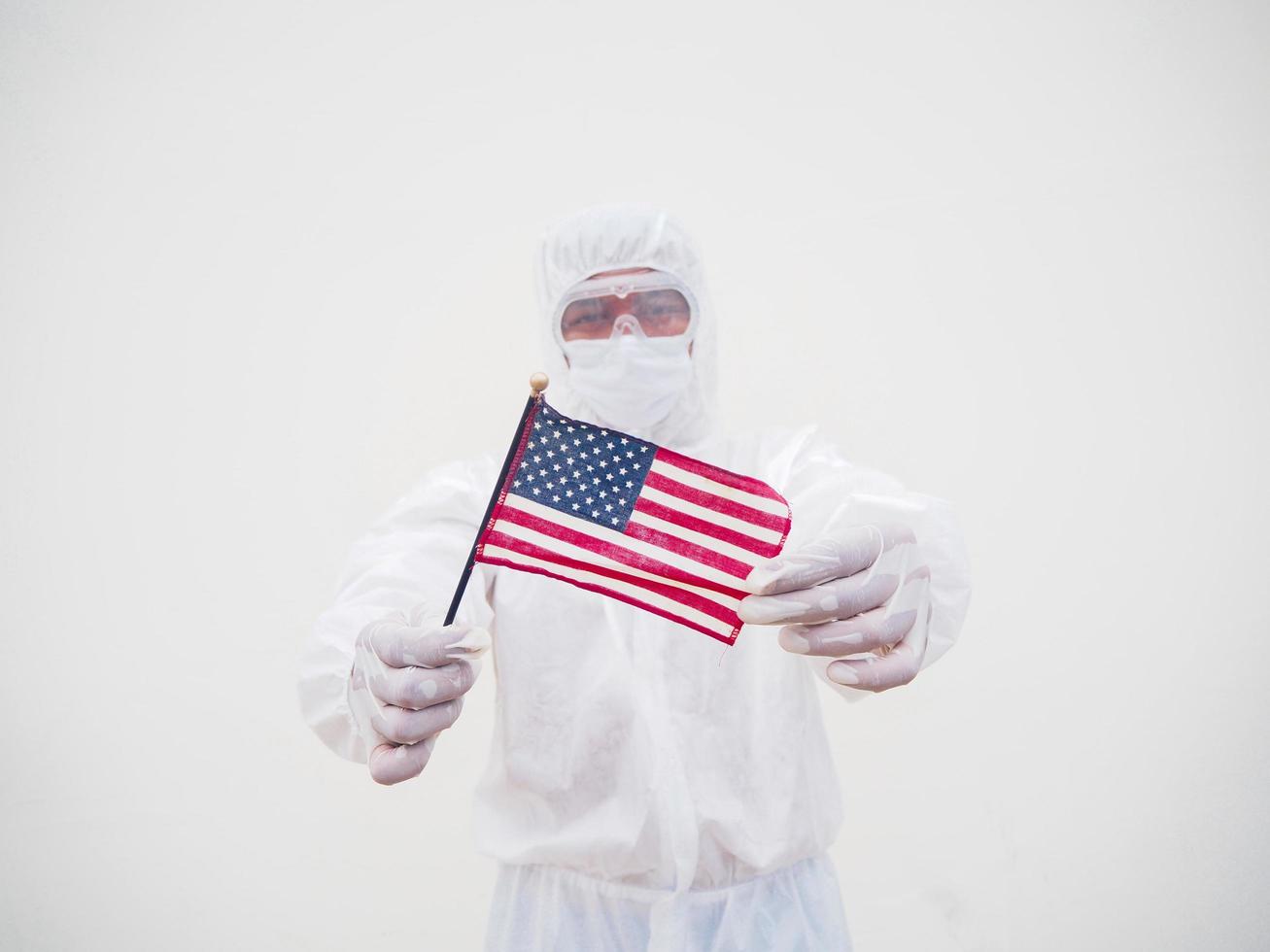 Portrait of doctor or scientist in PPE suite uniform holding national flag of United states of America. COVID-19 concept isolated white background photo