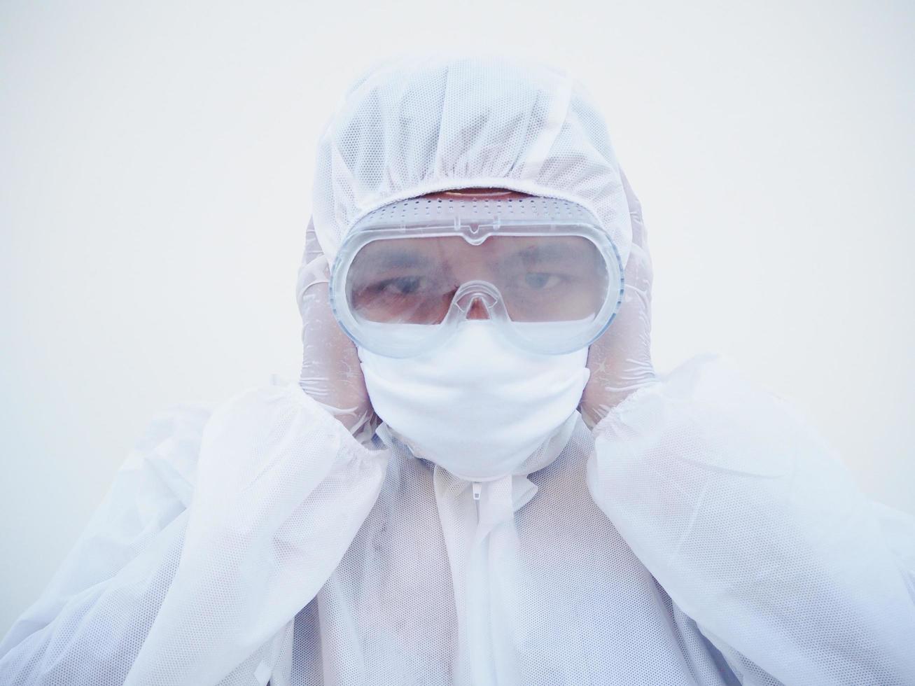 médico o científico asiático con uniforme de suite ppe cubre las orejas con las manos. peligro de coronavirus o covid-19 concepto aislado fondo blanco foto