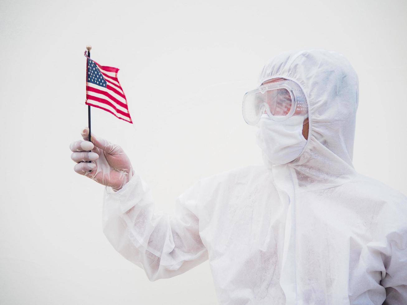 Portrait of doctor or scientist in PPE suite uniform holding national flag of United states of America. COVID-19 concept isolated white background photo