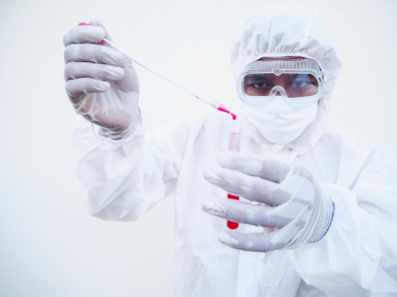 Asian doctor or scientist in PPE suite uniform. Personal protective equipment suit dropping a blood into blood test tube. coronavirus or COVID-19 concept isolated white background photo