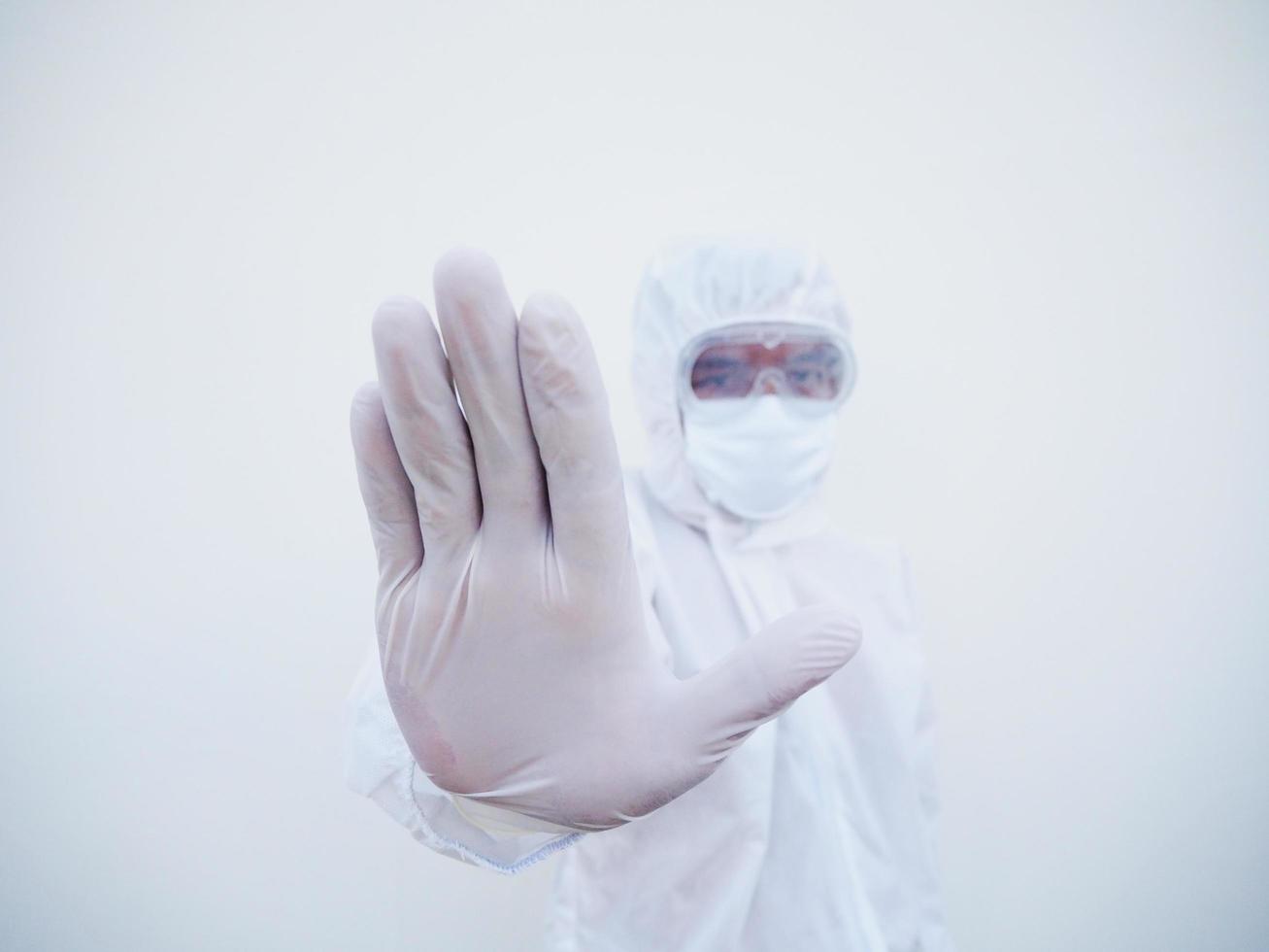 Asian male doctor or scientist in PPE suite uniform showing stop sign while looking ahead. coronavirus or COVID-19 concept isolated white background photo