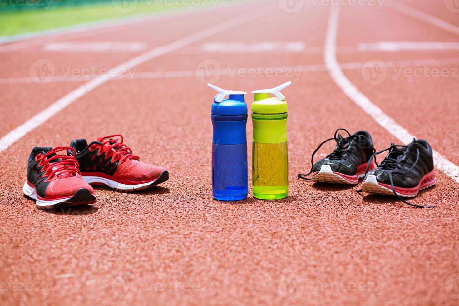 shoes and bottles water drink in Running lane track. exercise concept. photo