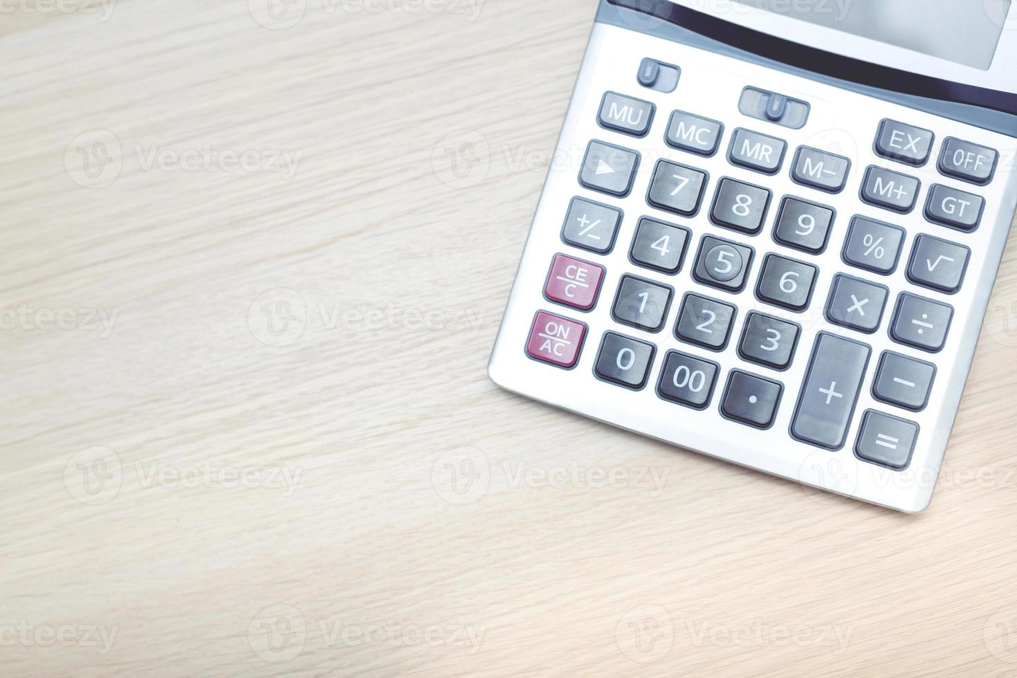 close up calculator focus at on press button keyboard on the wood table office. concept calculate account finance. photo