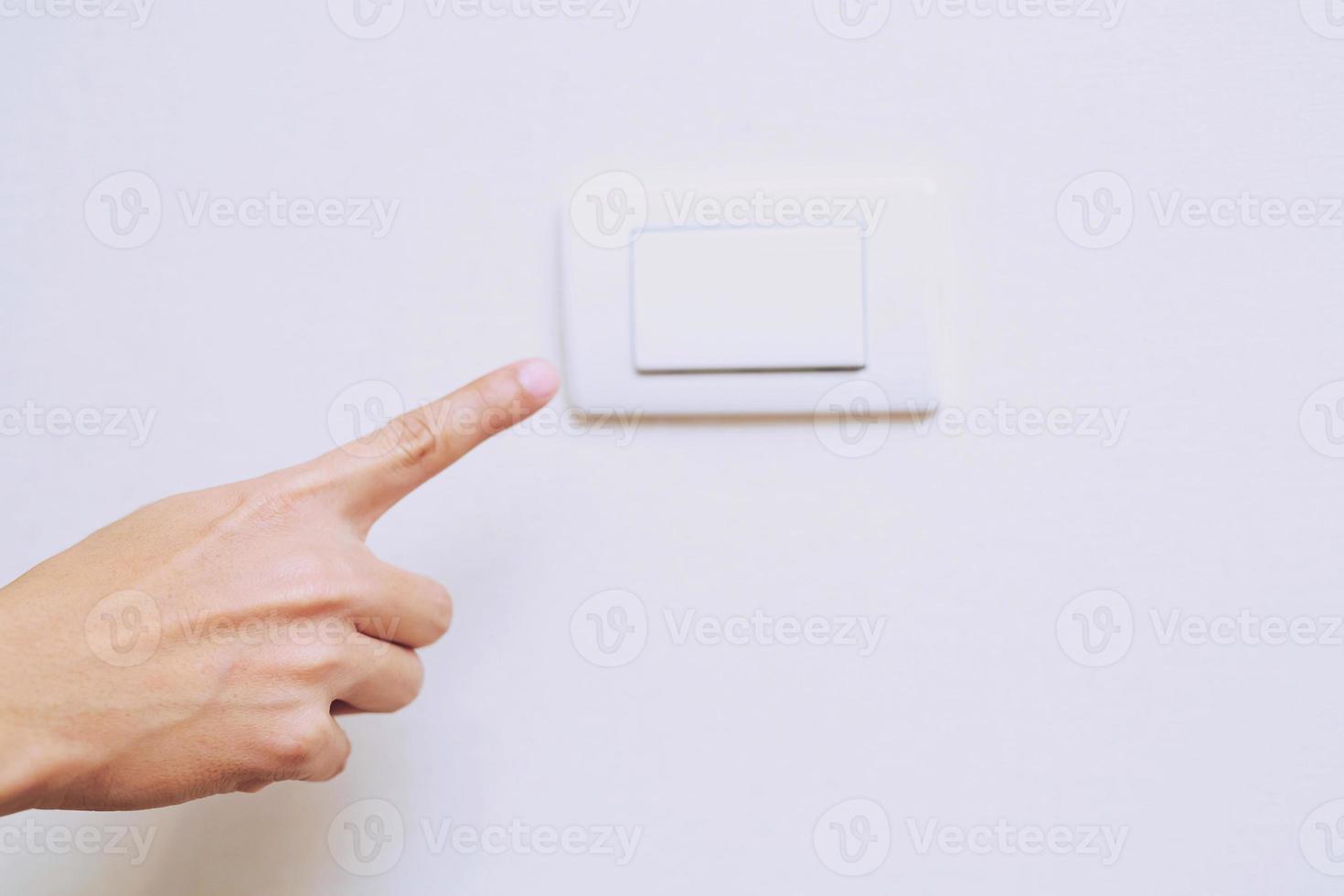 Turn off the light, close up finger man hand is closing the power switch with wall at home  to save energy. reduce global warming. photo