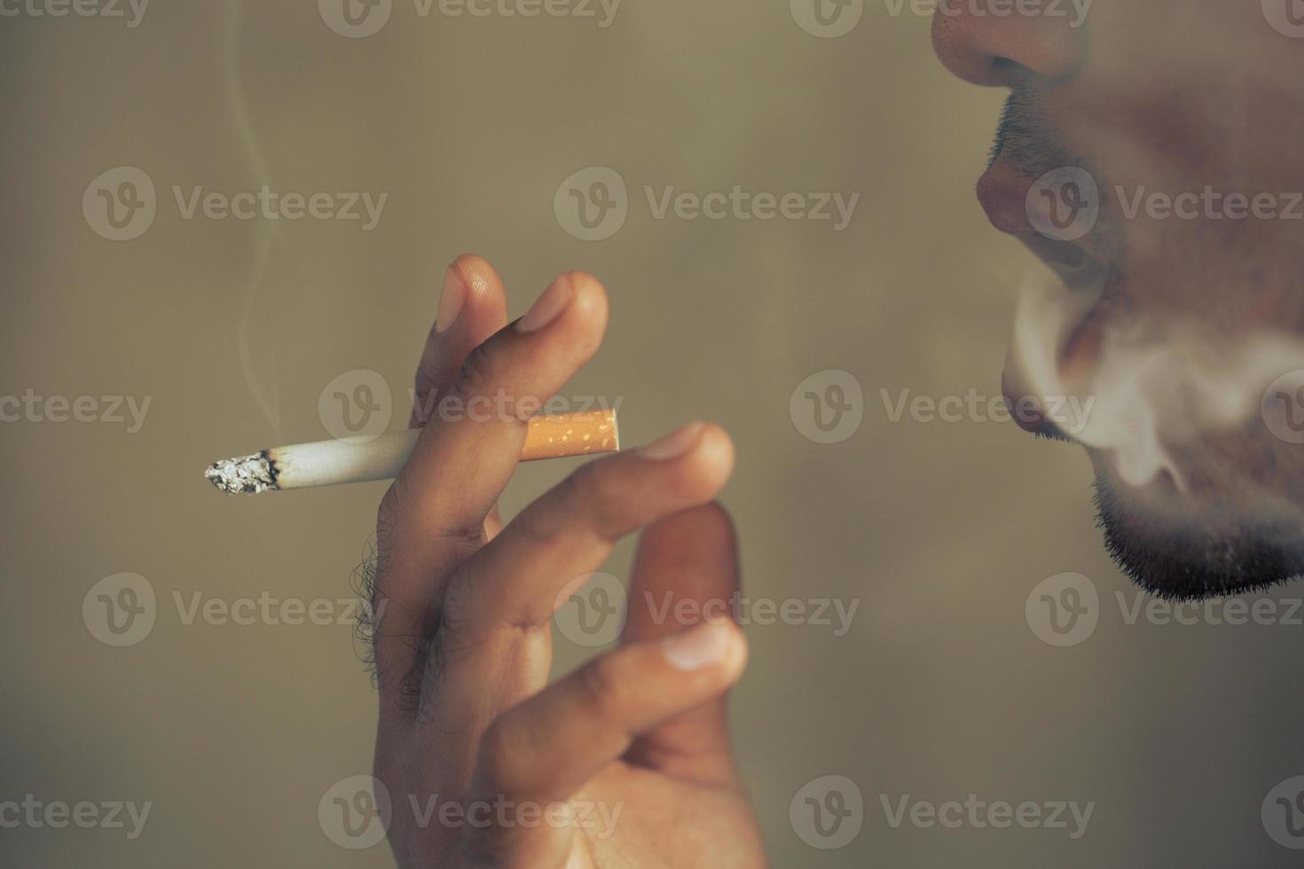 man smoking a cigarette. Cigarette smoke spread. photo