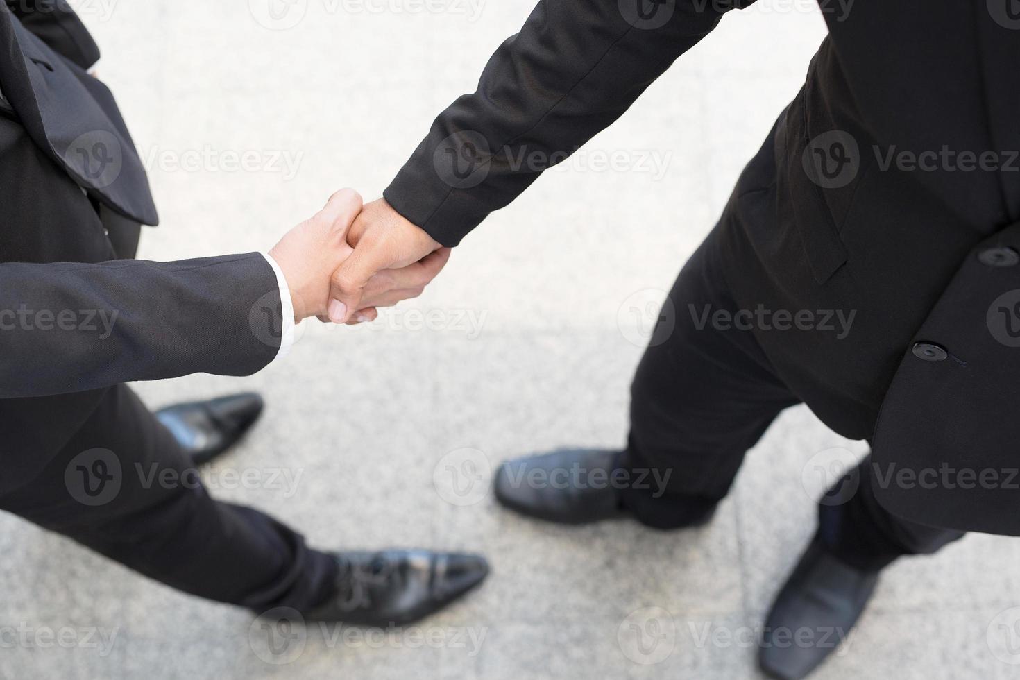 primer plano de un inversor de apretón de manos de hombre de negocios entre dos colegas ok, tener éxito en los negocios tomados de la mano. foto