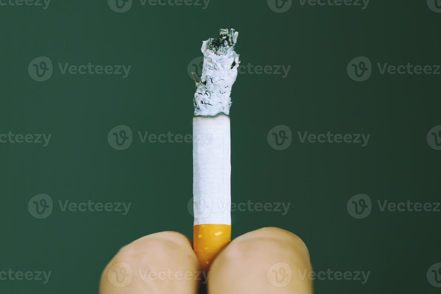 man holding smoking a cigarette in hand. Cigarette smoke spread. photo