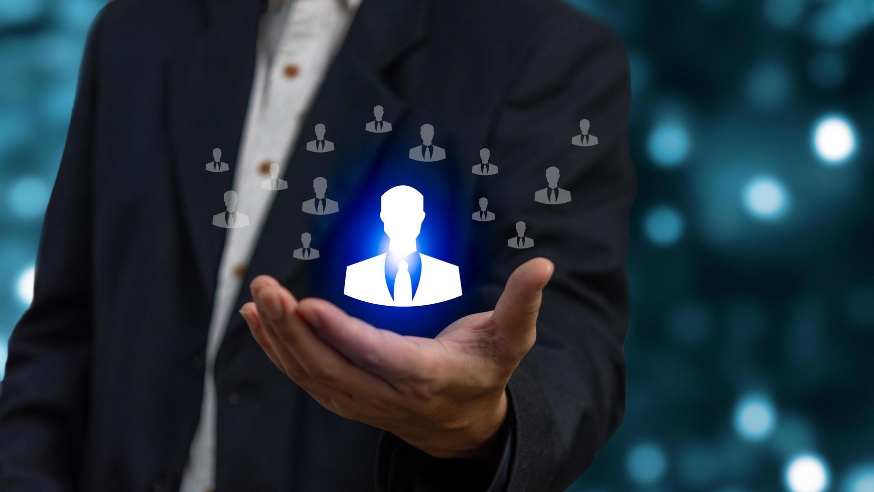 Magnifier glass focus to manager icon which is among staff icons for human development recruitment leadership and customer target group concept. photo