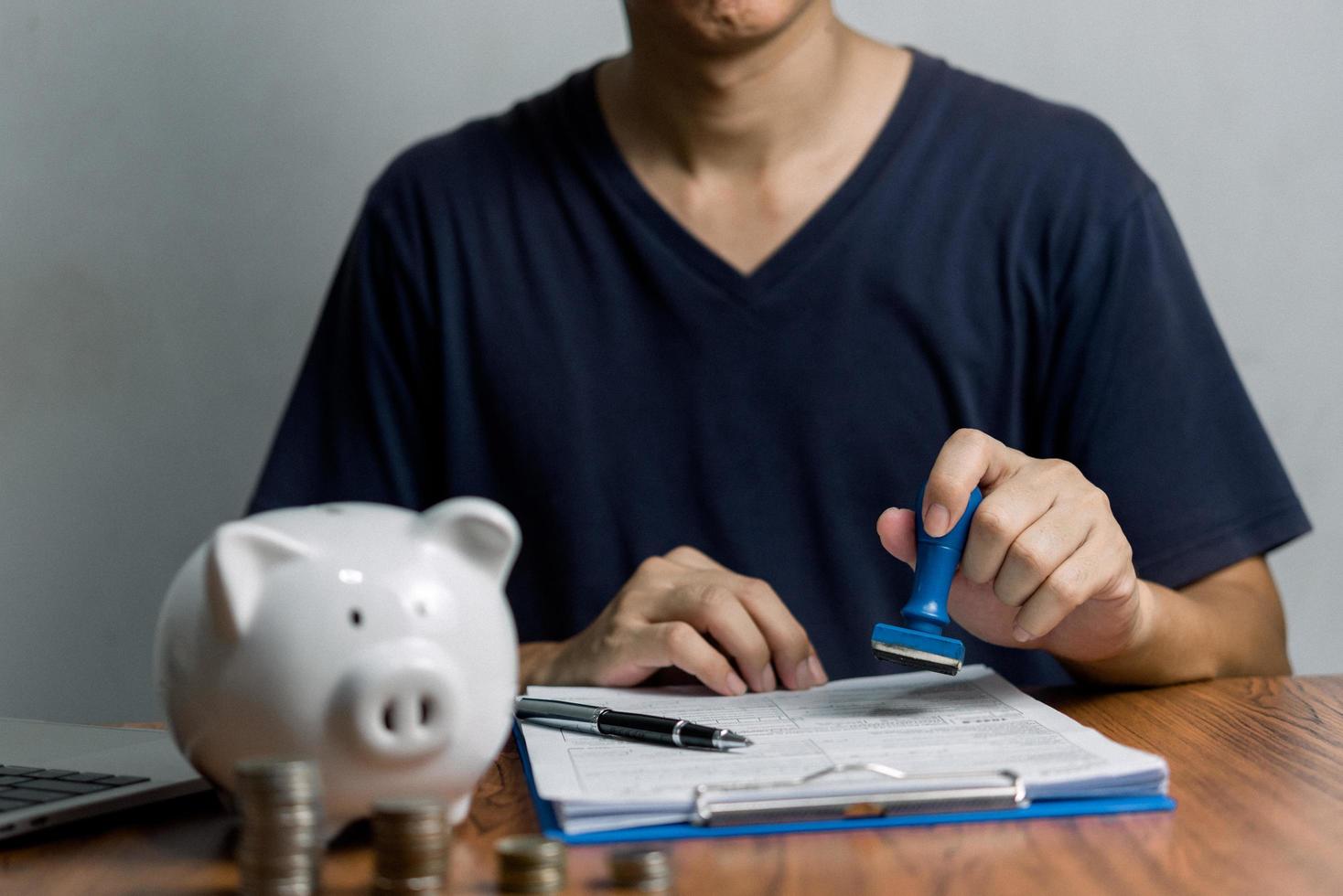 Man stamping approval of work finance banking or investment marketing documents on desk. photo