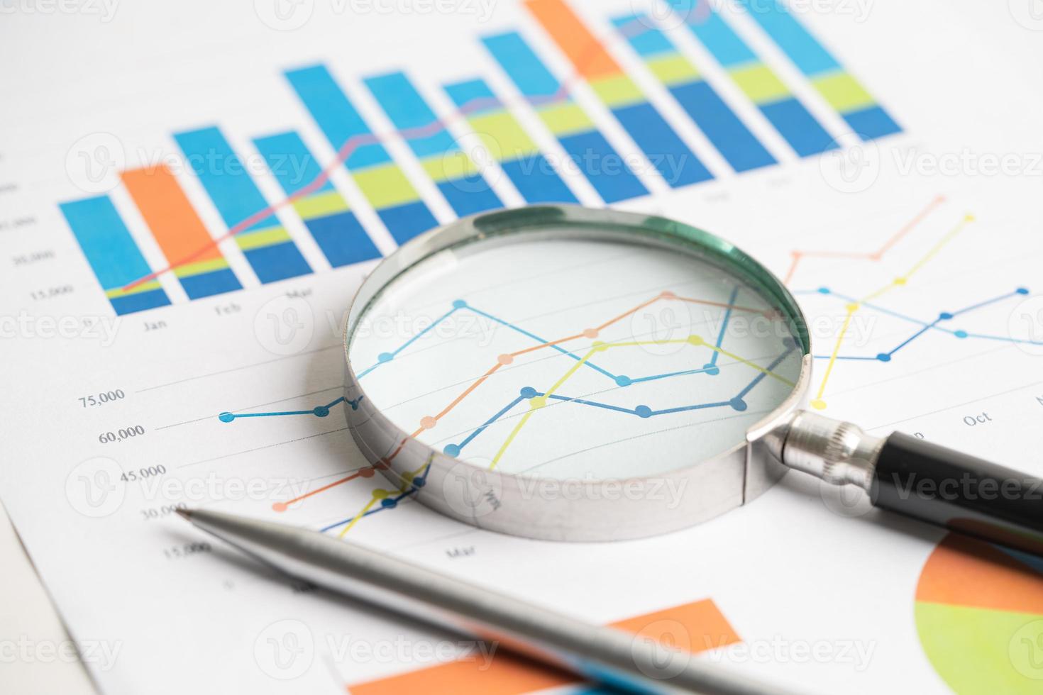 Magnifying glass on chart graph spreadsheet paper. Financial development, Banking Account, Statistics, economy, Stock exchange trading, Business office company meeting concept. photo