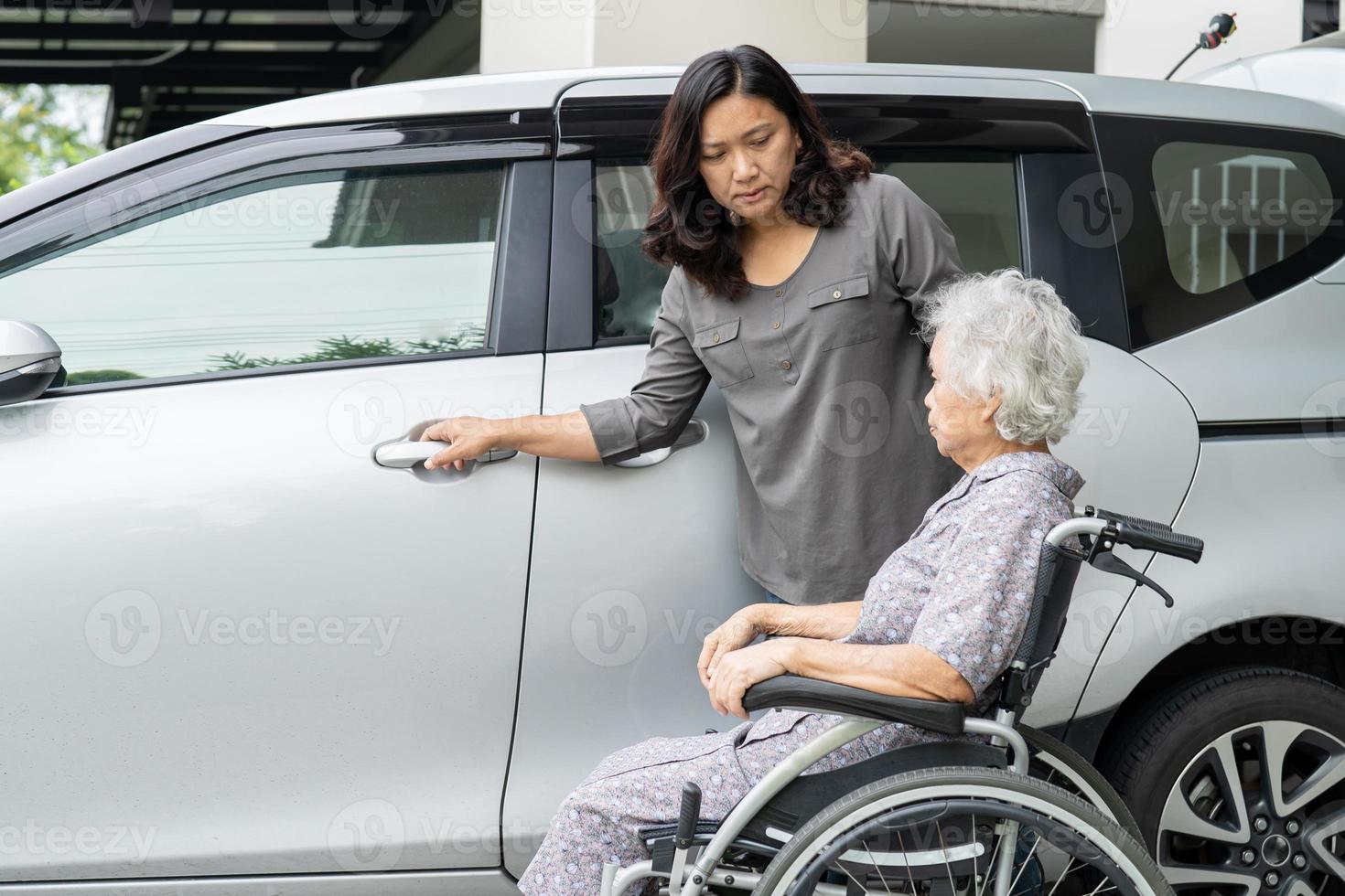 Help and support asian senior or elderly old lady woman patient prepare get to her car. photo