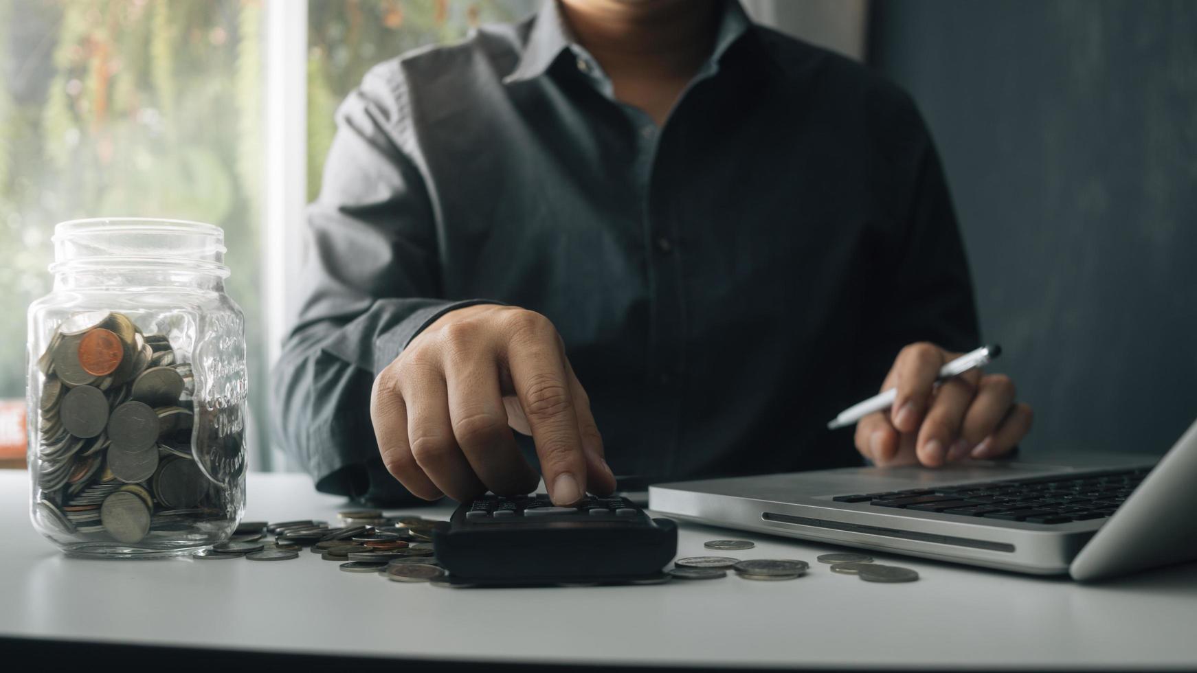 Woman entrepreneur using a calculator with a pen in her hand, calculating financial expense at home office photo