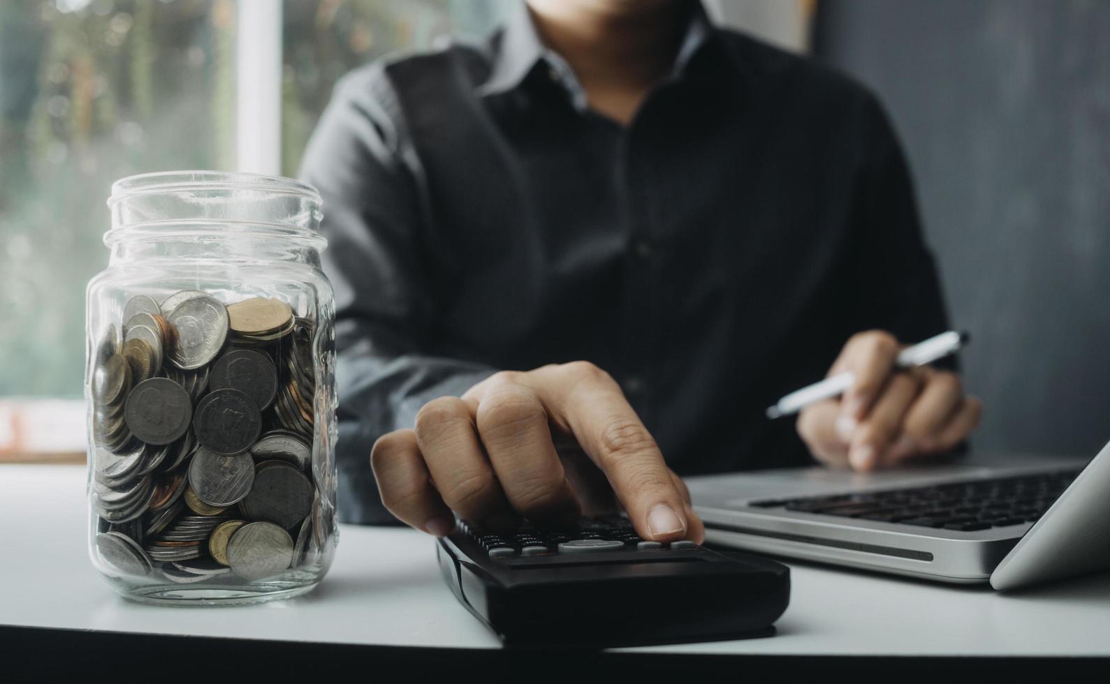 Woman entrepreneur using a calculator with a pen in her hand, calculating financial expense at home office photo