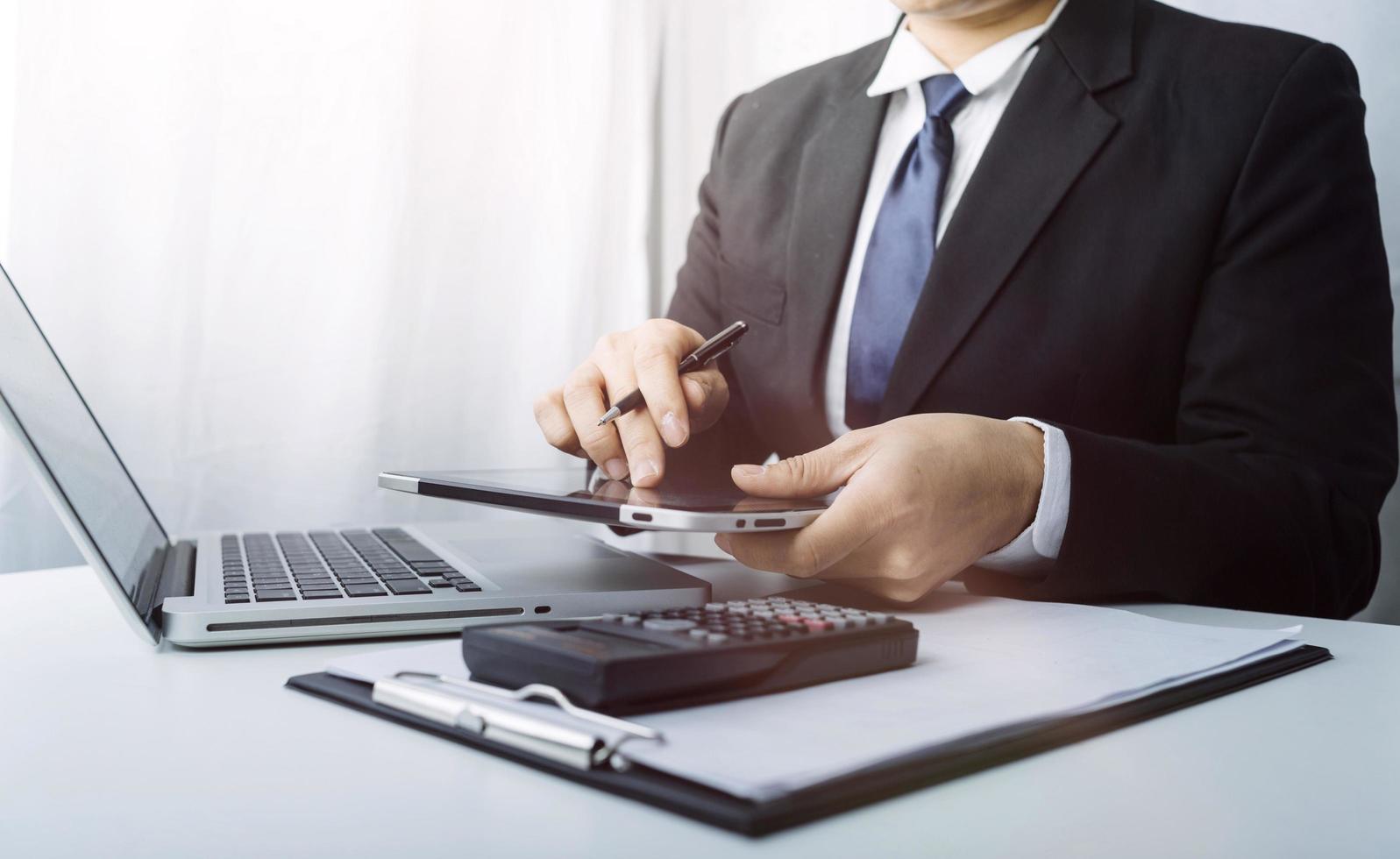 mujer empresaria usando una calculadora con un bolígrafo en la mano, calculando los gastos financieros en la oficina del hogar foto