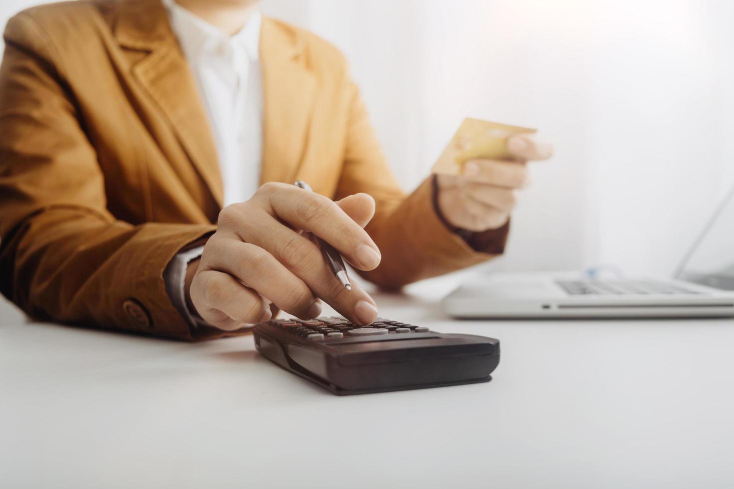 Woman entrepreneur using a calculator with a pen in her hand, calculating financial expense at home office photo