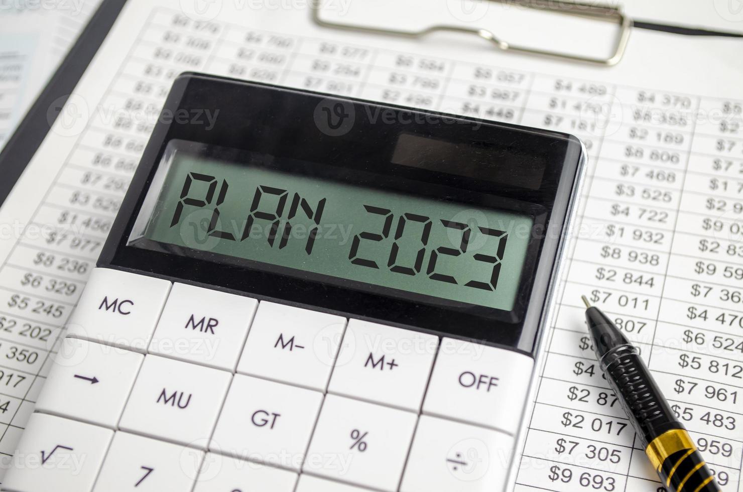 Calculator with Year 2023 plan on chart and pen photo