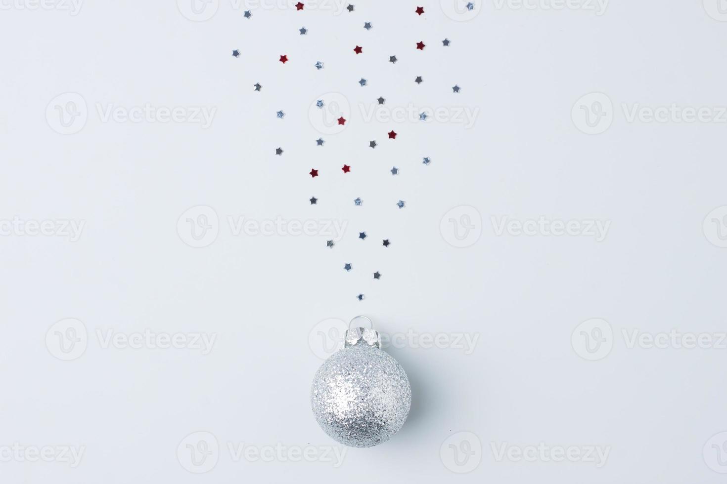 Christmas grey minimal background with grey ball and confetti. Flat lay, copy space photo