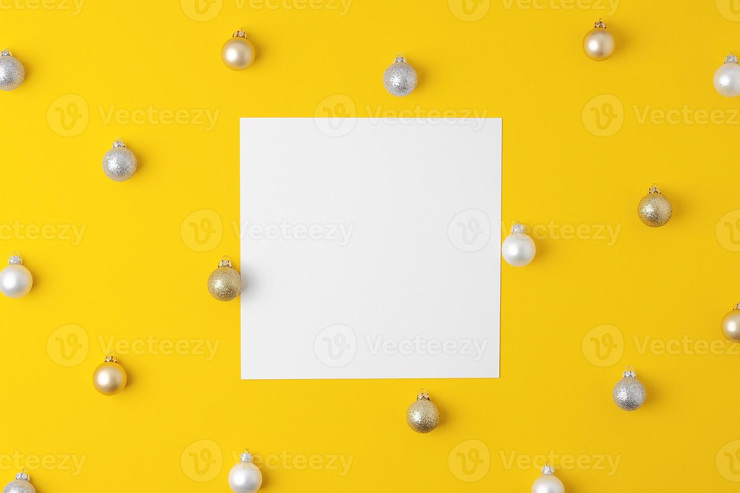 Christmas yellow minimal background with mock up greetings card and ball. Flat lay, copy space photo