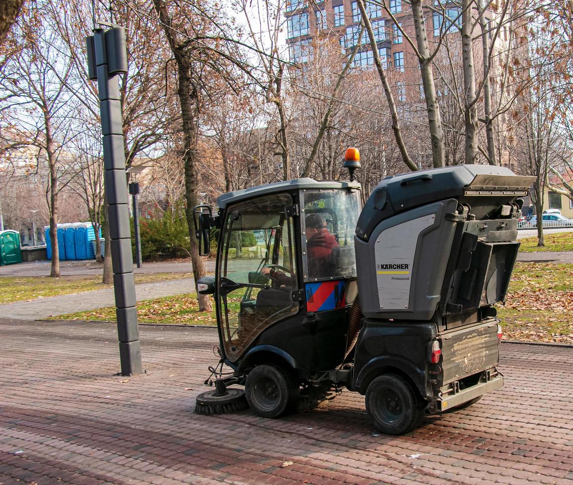 Dnepropetrovsk, Ukraine - 11.22.2021 Municipal service carries out seasonal works in the park. The brushes sweep the asphalt. photo