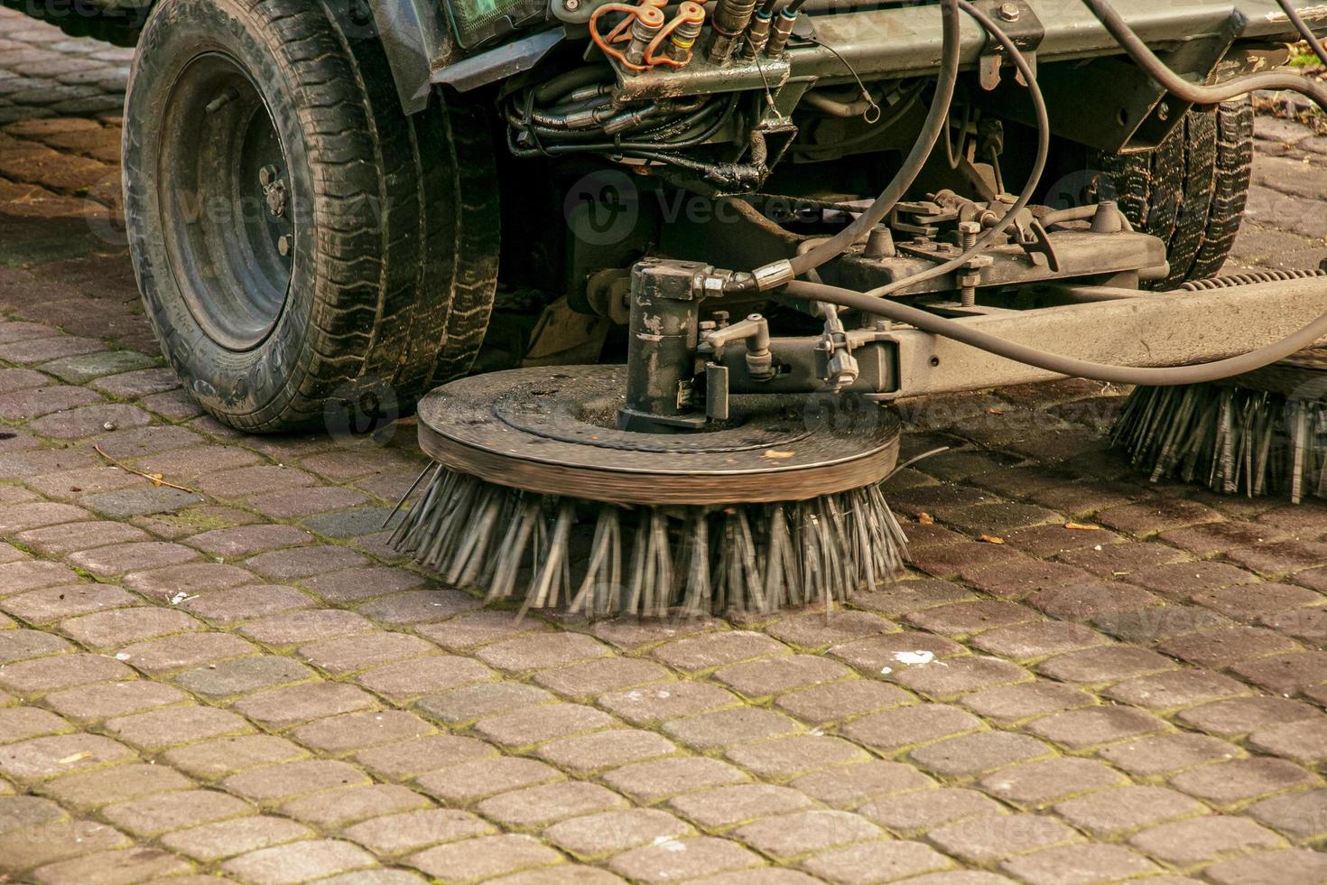 The municipal service conducts seasonal work in the park. The sweeper picks up a lot of debris. The brushes sweep the asphalt photo