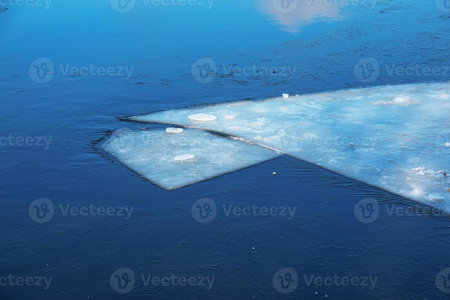 Winter nature background with blocks of ice on frozen water in spring. Abstract background of drifting ice on water photo