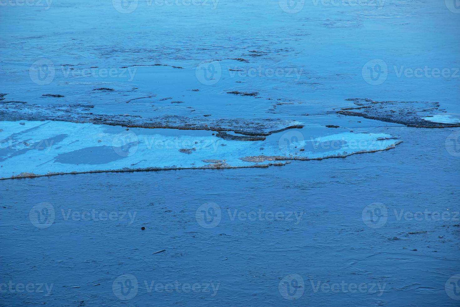 Winter nature background with blocks of ice on frozen water in spring. Abstract background of drifting ice on water photo