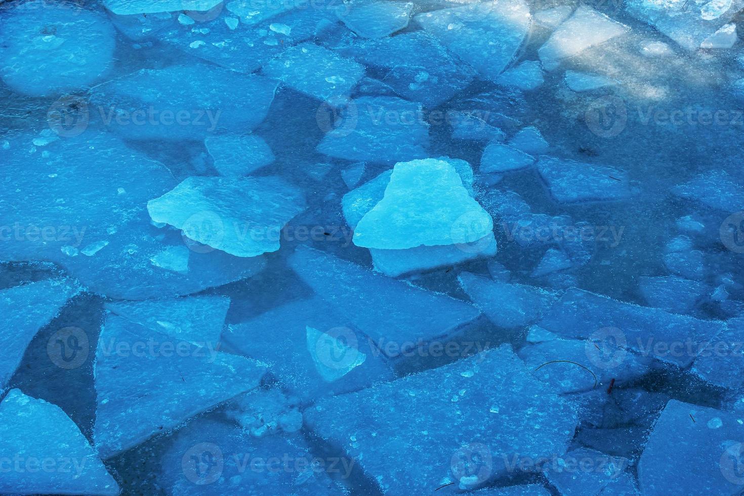 Winter nature background with blocks of ice on frozen water in spring. Abstract background of drifting ice on water photo