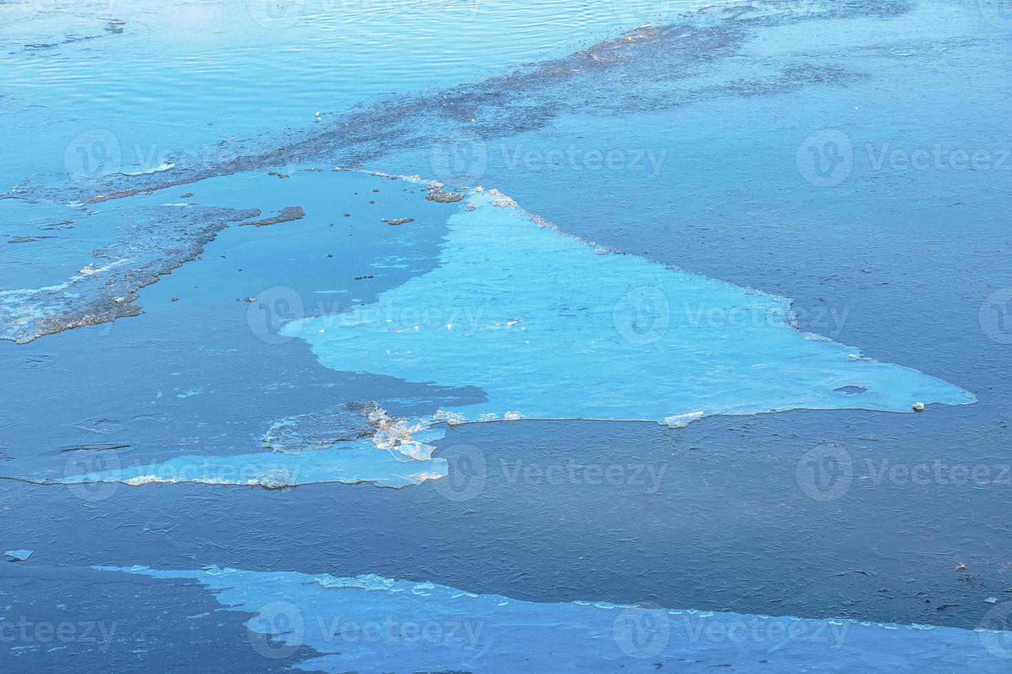Winter nature background with blocks of ice on frozen water in spring. Abstract background of drifting ice on water photo