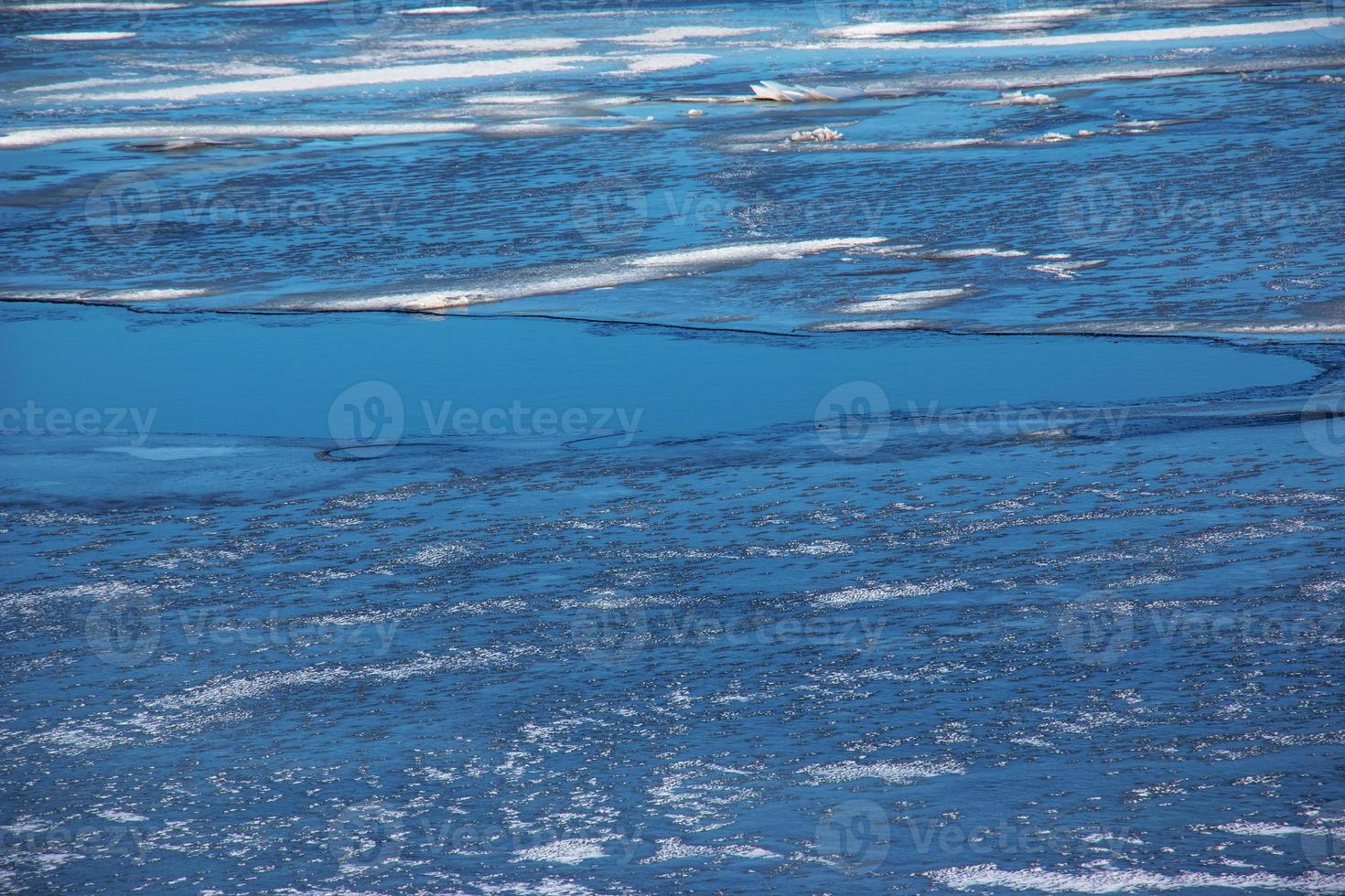Winter nature background with blocks of ice on frozen water in spring. Abstract background of drifting ice on water photo
