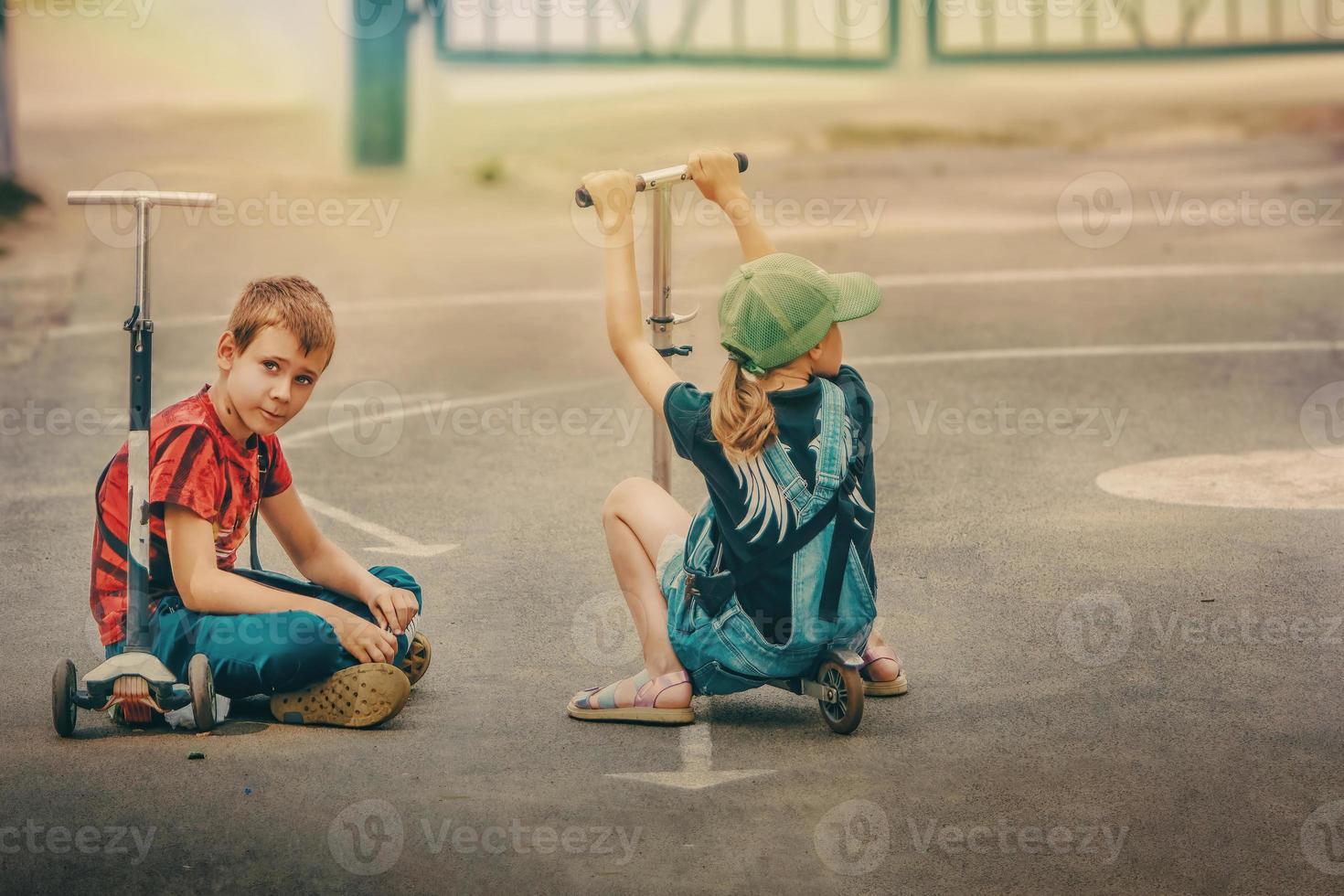 krichov, región de mogilev, bielorrusia, 2022 - una niña y un niño están sentados en scooters descansando jugando lo suficiente foto