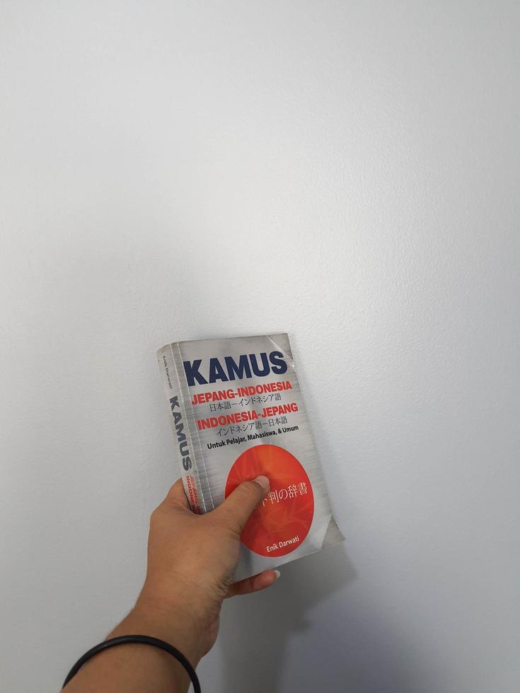 West Java, August 2022. A hand is holding a Japanese-Indonesian dictionary for students, students and the general public photo