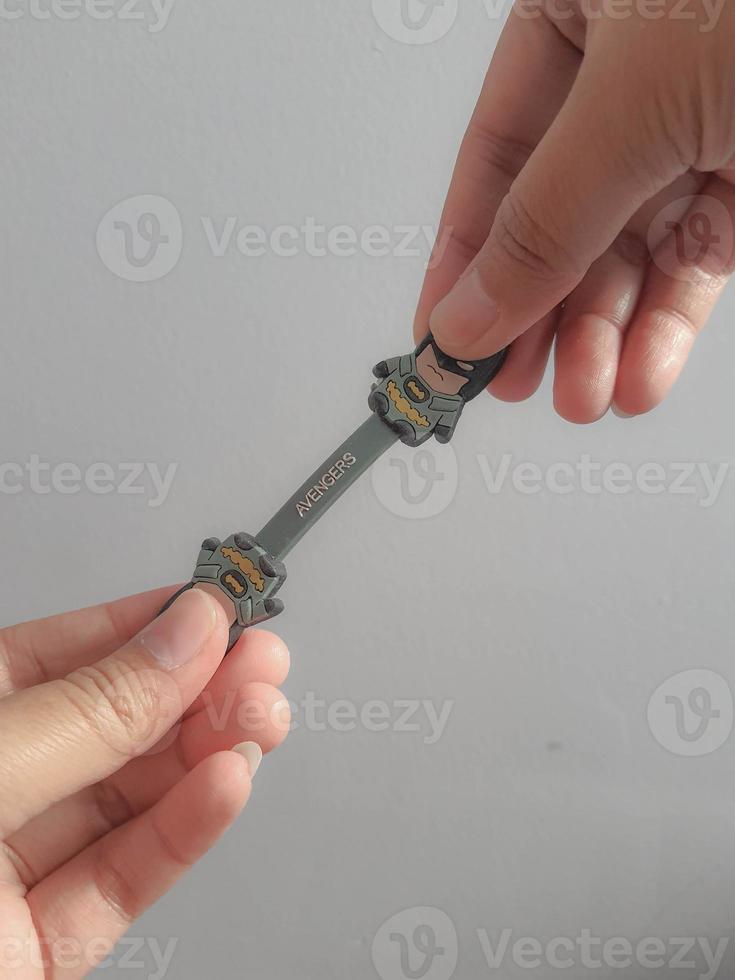 Jakarta, Indonesia in July 2021. A hand is holding a cable holder that functions to tidy up folded cables photo