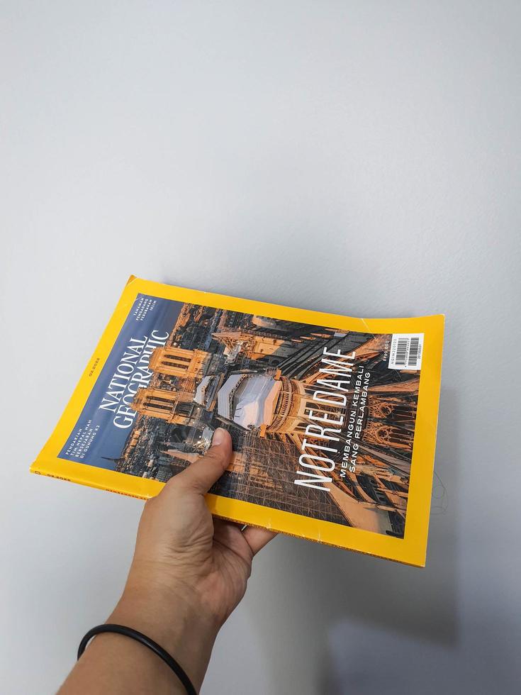 West Java in August 2022. A hand holds the Indonesian version of the National Geographic magazine. photo