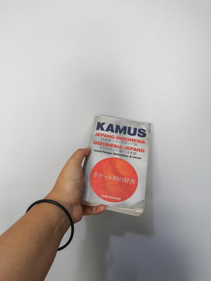 West Java, August 2022. A hand is holding a Japanese-Indonesian dictionary for students, students and the general public photo