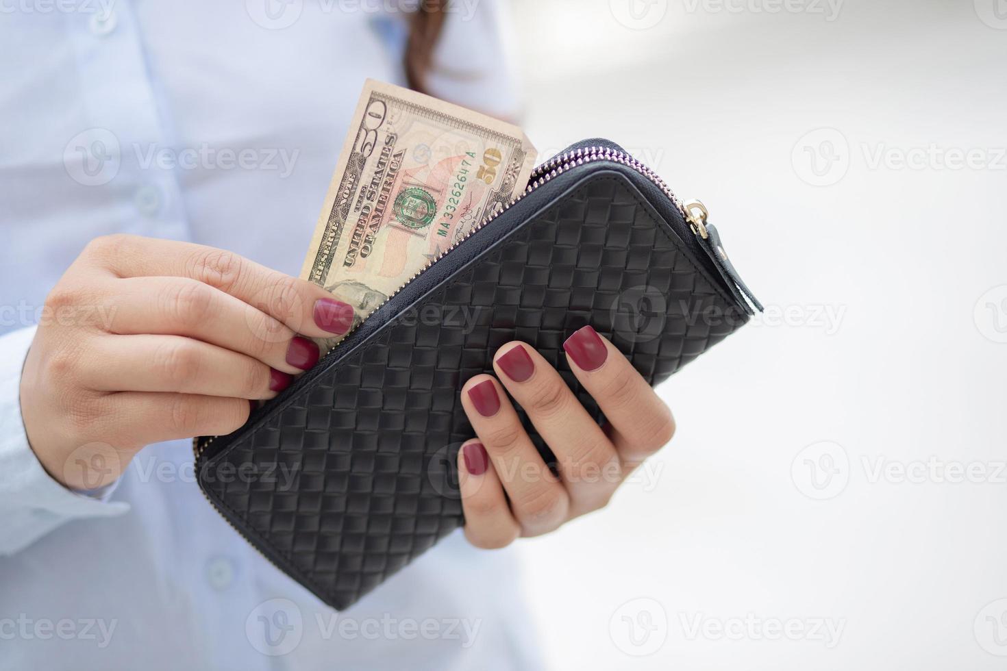 mujer sosteniendo una billetera de moda, está comprando en una tienda por departamentos. foto