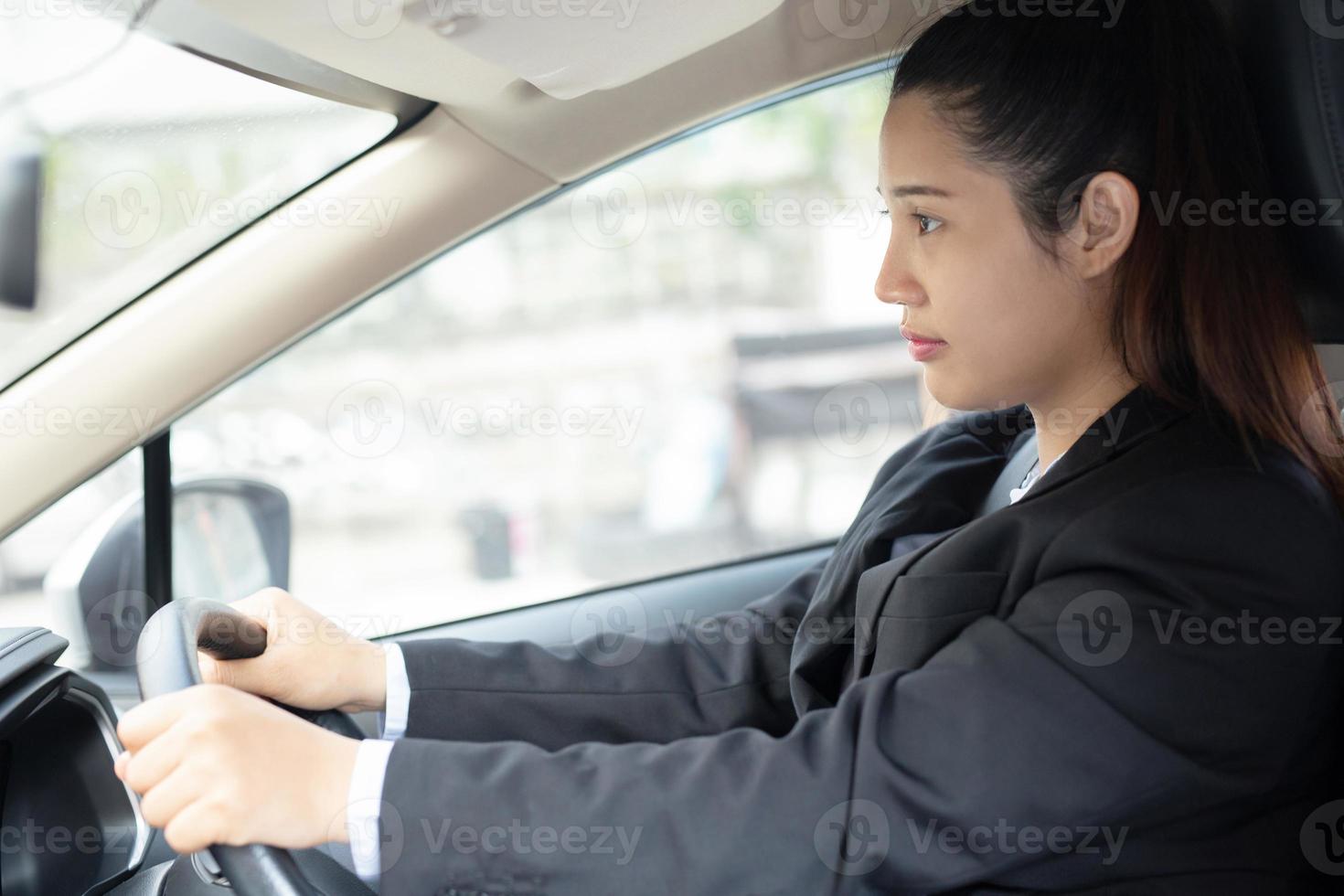 A woman is driving to work at the office, focus on face photo