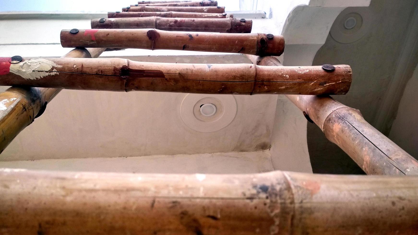 un edificio antiguo con fachada dañada con escalera de madera junto a la pared foto