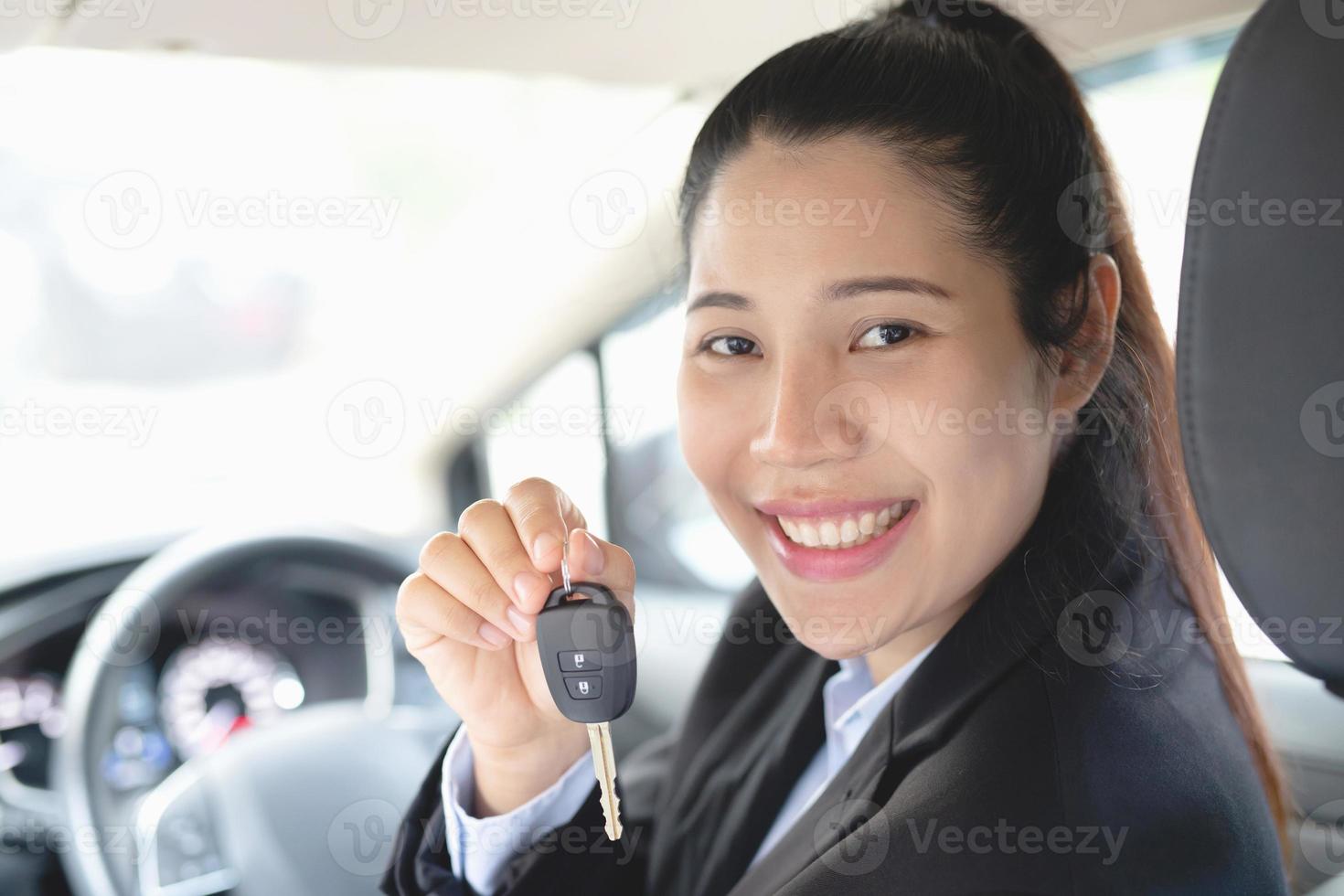 la vendedora tiene las llaves del coche nuevo. listo para entregar a los clientes en la sala de exposición. foto