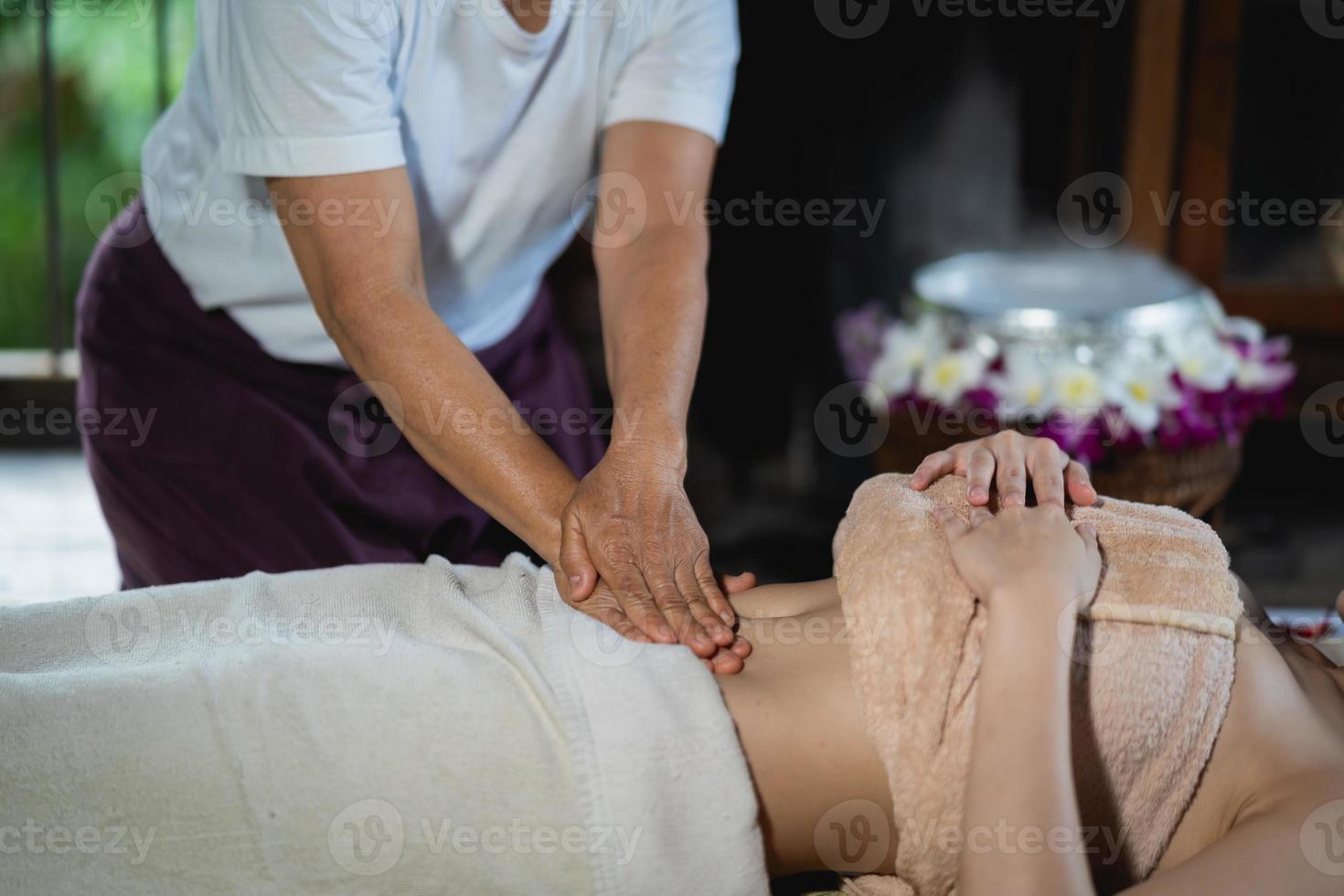 Abdominal massage and spa relaxing treatment of office syndrome traditional thai massage style. Asain female masseuse doing massage treat abdomen relax and stress for office woman tired from work. photo