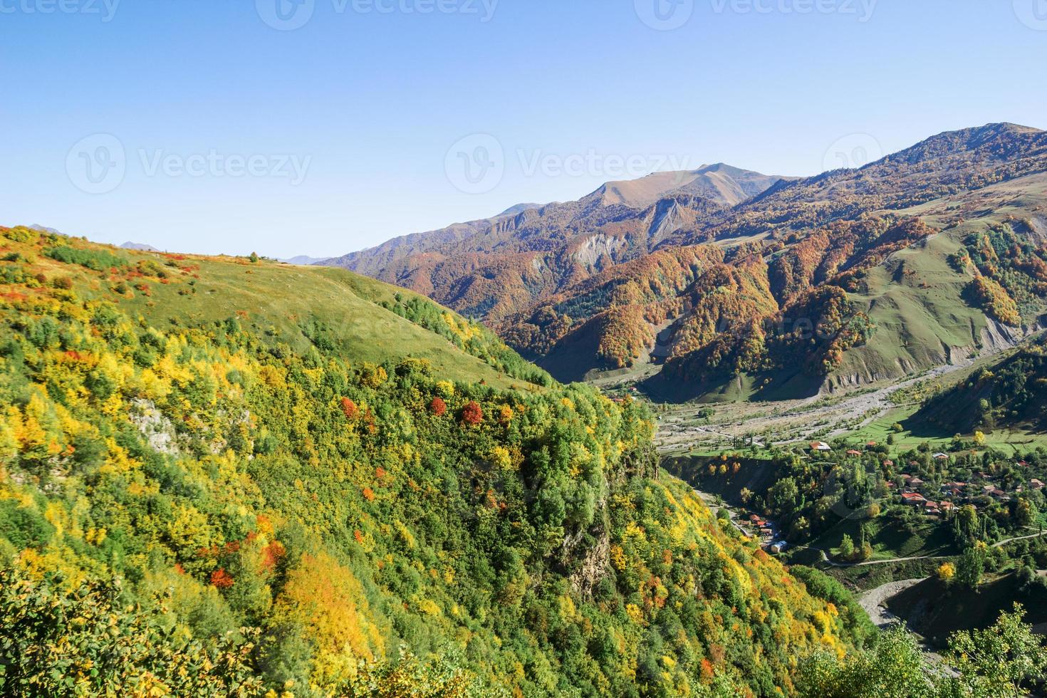 hermoso paisaje con montañas, pueblos y carreteras en clima soleado de otoño. montañas del cáucaso, georgia. foto